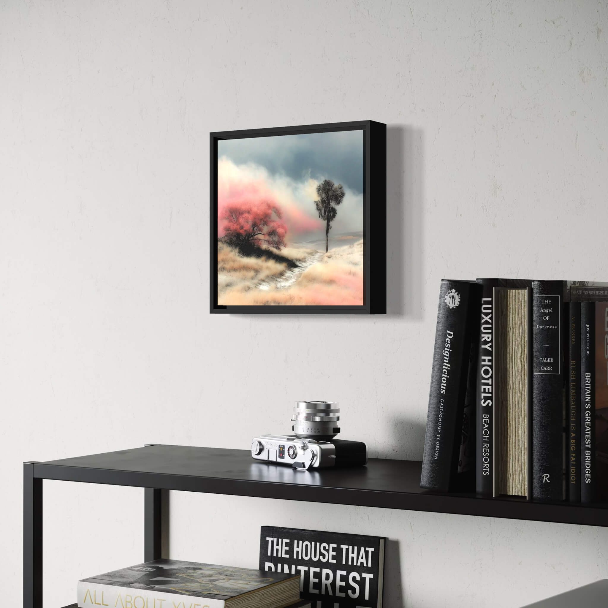 Framed artwork of a serene landscape on a wall above a shelf with books and decor items.
