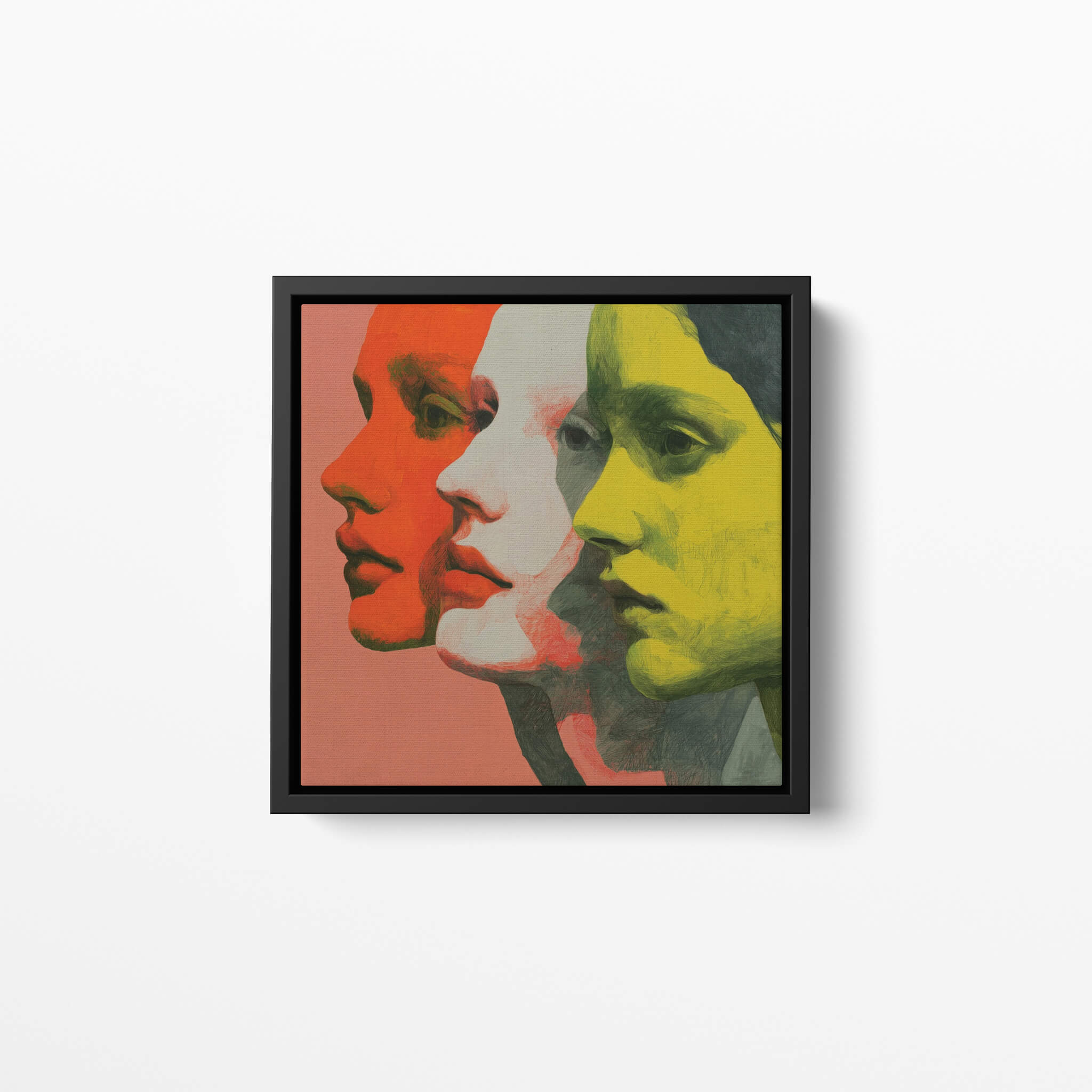 Framed artwork of three stylized faces in orange, white, and yellow on a white background