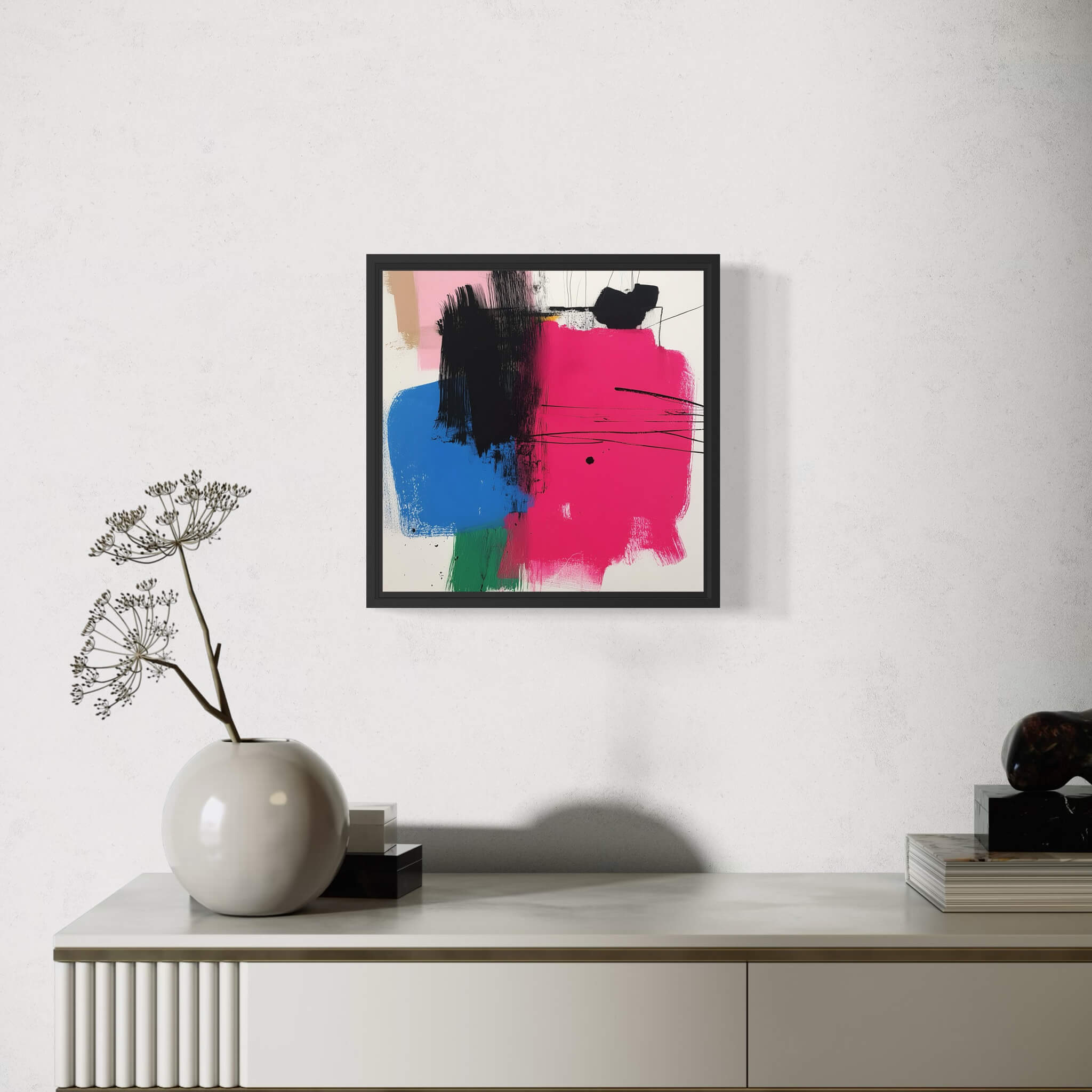 Abstract art piece on a wall above a white cabinet with decorative items.