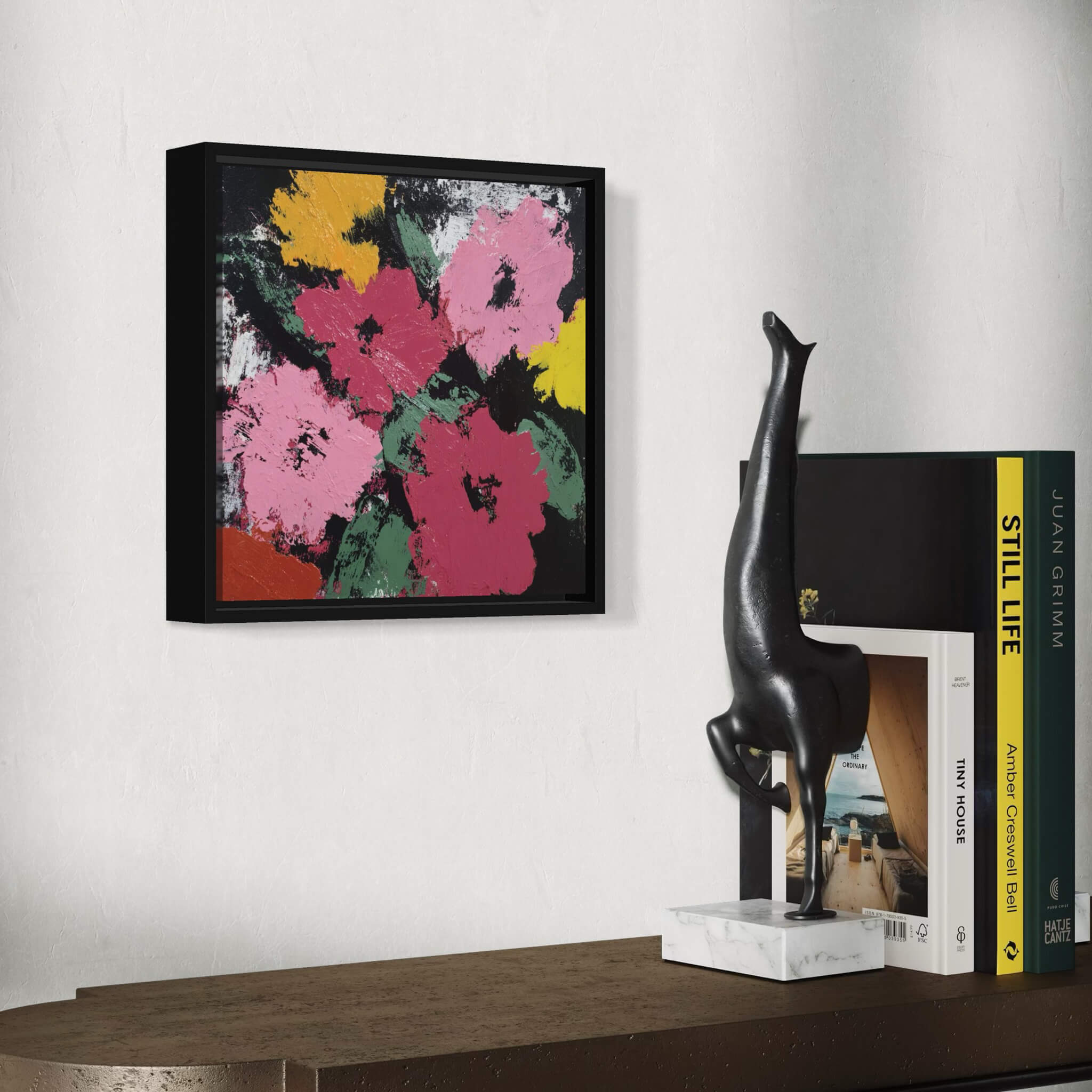 Abstract floral artwork on a wall with a sculpture and books on a table.