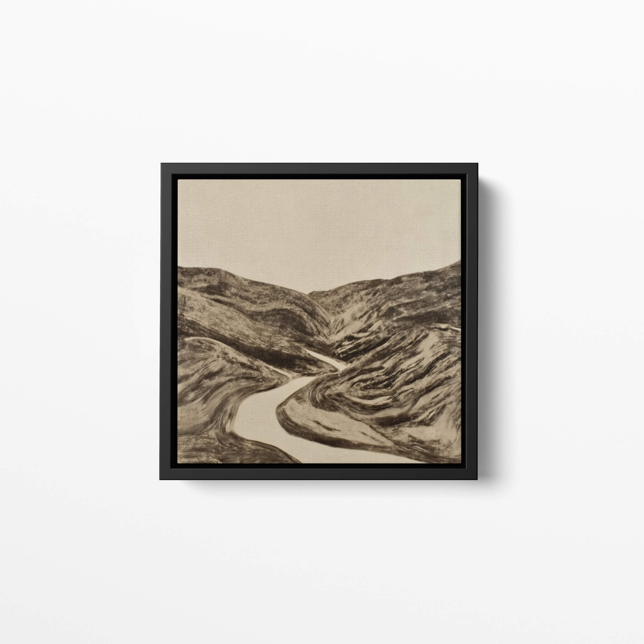 Framed landscape fine art print of a river winding through mountains on a white wall.
