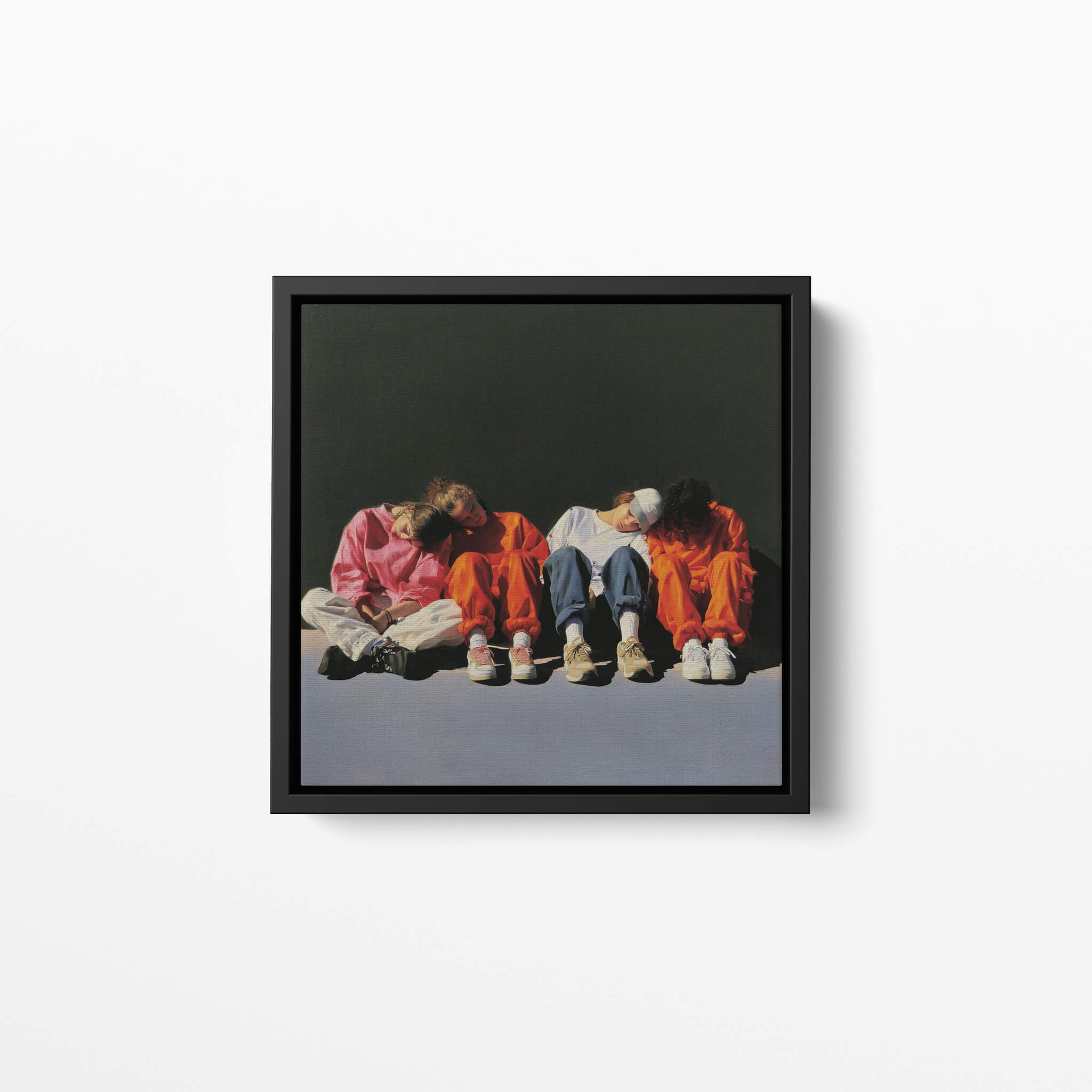 Framed artwork of four people sitting on the ground against a dark background