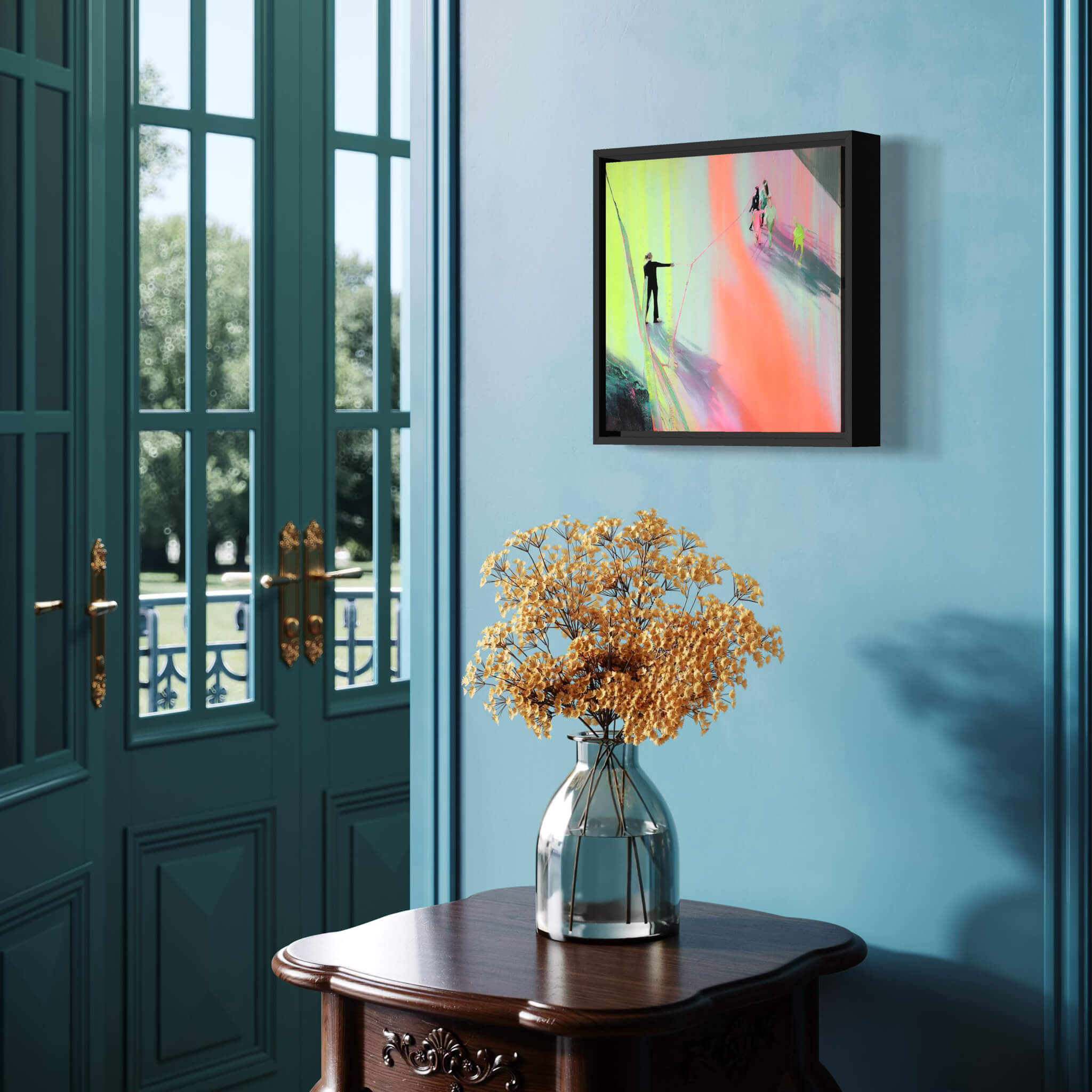 Framed abstract artwork on a blue wall with a vase of flowers on a wooden table.