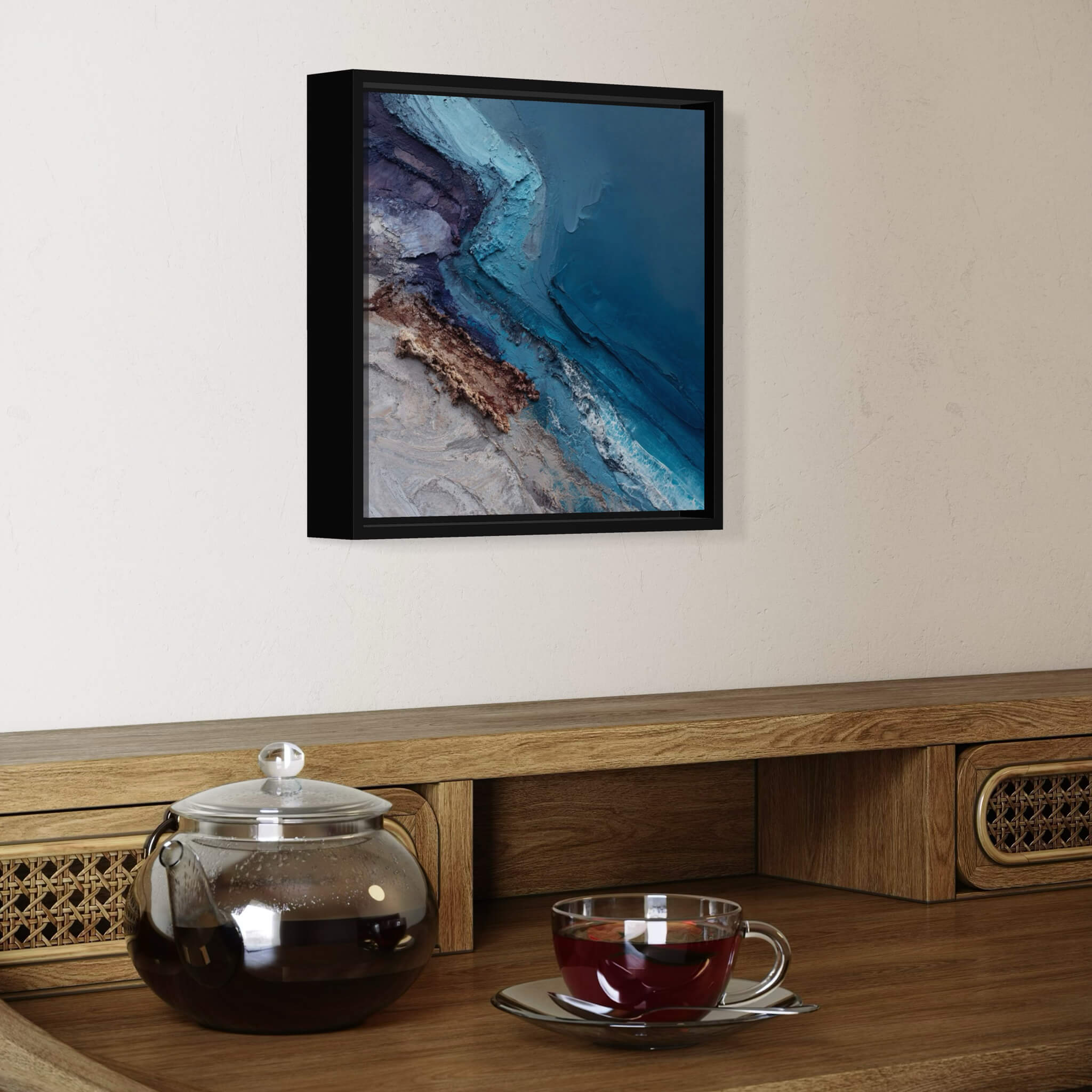 Tea set on a wooden surface with abstract art of the ocean above