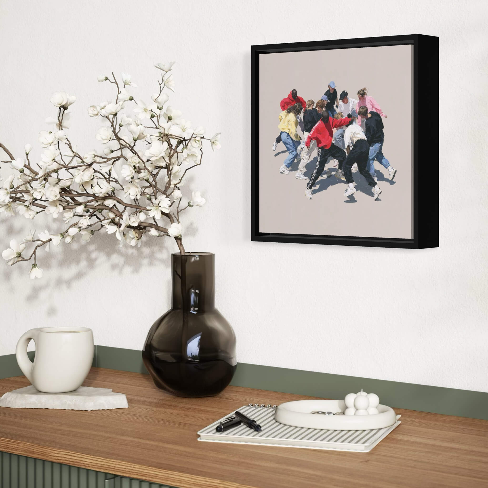 Framed artwork of a group of people dancing on a wall above a wooden table with decorative items.